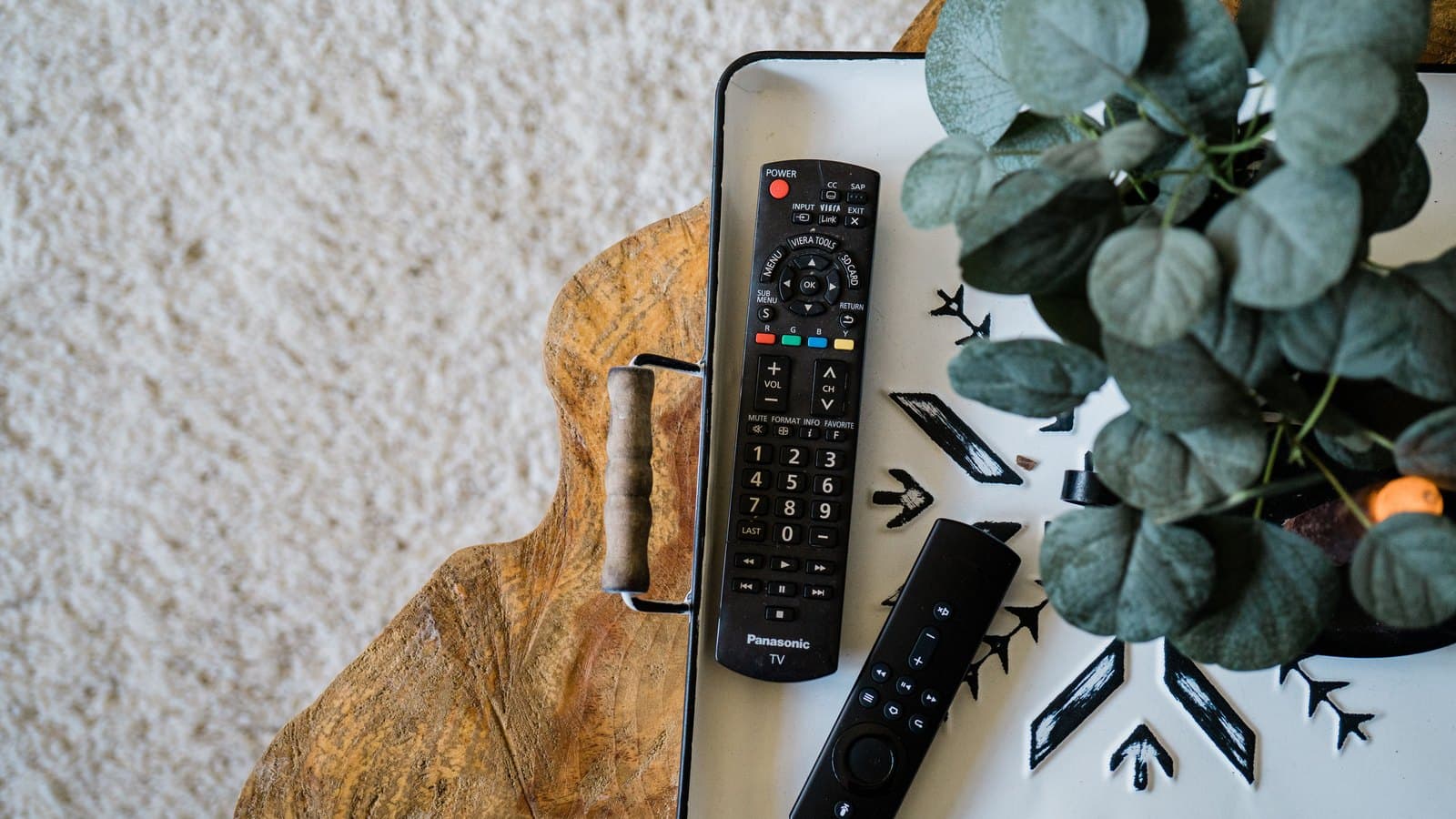 Piloty do telewizora i przystawki streamingowej na tacy — wybór dekodera IPTV do domu