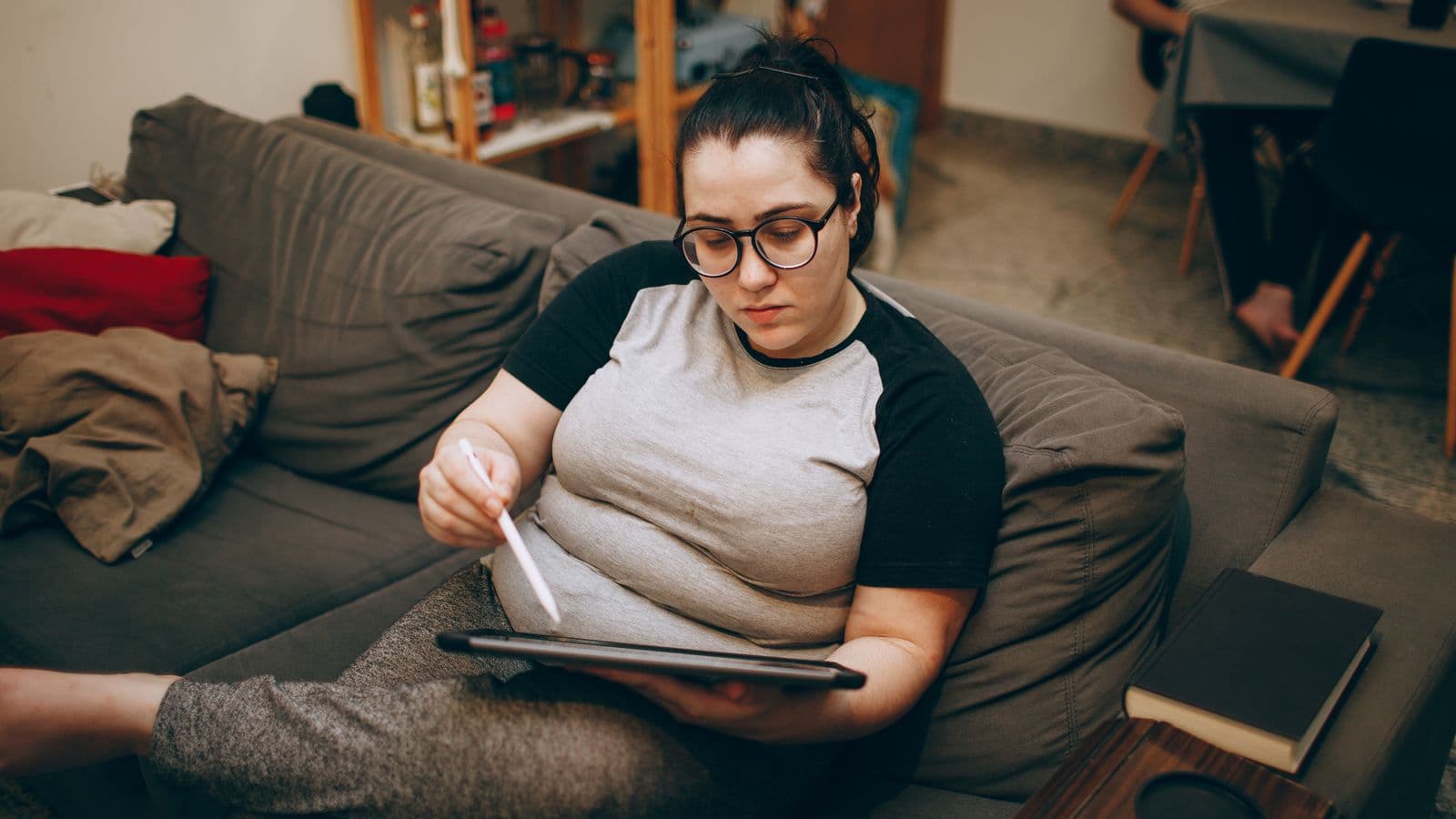 Kobieta na kanapie testuje dostęp do IPTV na tablecie